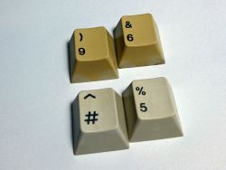 The same two caps after Retr0brighting, alongside two other yellowed caps from the same set.