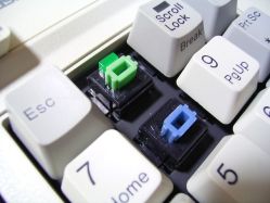 Green Alps switch with LED fitted, in a blue Alps Panasonic Business Partner 286 keyboard