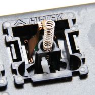 Black switch internals as seen from the rear, including the click arm