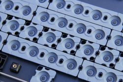 Bottom view of rubber domes. The individual domes along the middle are designed to allow the LEDs on the PCB to pass through.
