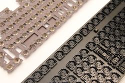 Underside of a rubber dome sheet (left) and the switch mounting plate from a Topre keyboard (right). The conic springs are still in place on the dome sheet.