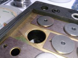 Underneath the plate, magnet strips, metal washers, rubber spacer for the plate<ref name="HaaTa"/>