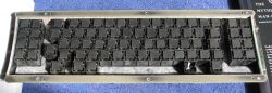 The underside of the upper half of a beam spring keyboard assembly, showing the fly plates and the switch modules.