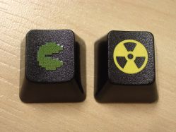 Comparison with double-shot moulding, showing the dark colour and raised printing (Pac-Man was mistakenly printed green in this example)