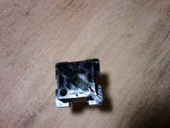 Cross reed, underside of slider. Magnet is somewhat visible in the center.