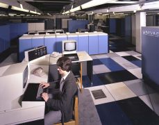 IBM 3036 Processor Complex Console. A UNIVAC mainframe and multiple terminals can be seen in the background.