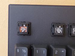 The clicky switch (left) has an inner slider which is orange, seen here through the transparent plunger.